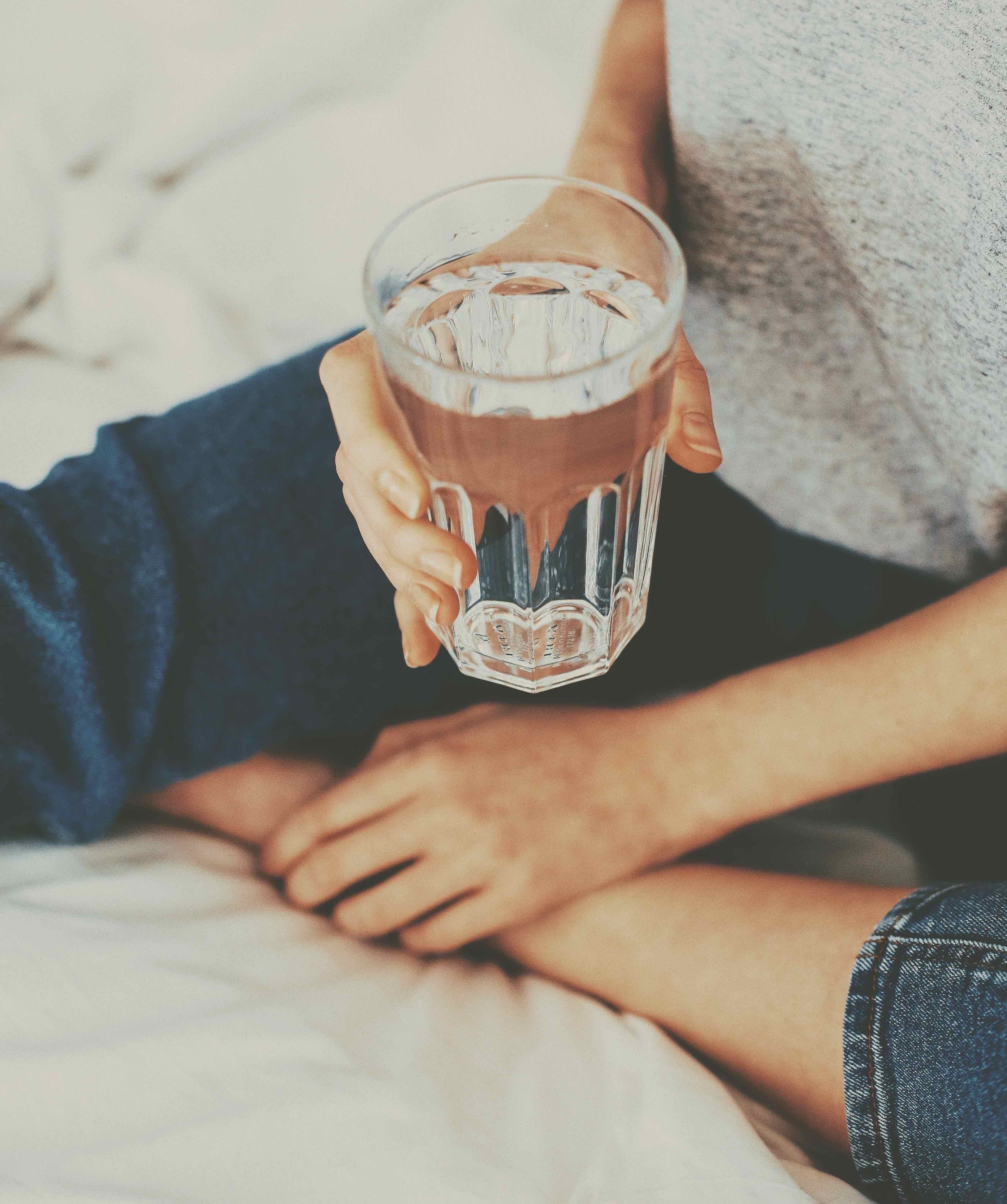 U Beauty Blog | Tips for Staying Sane While Staying Home | image of someone holding a glass of water