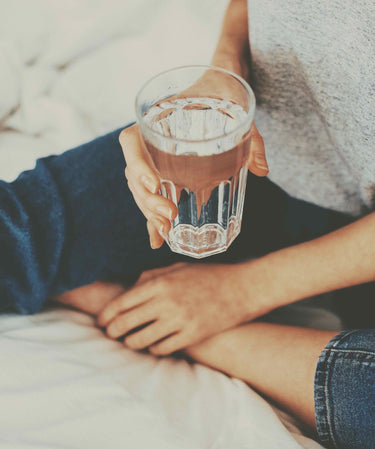 U Beauty Blog | Tips for Staying Sane While Staying Home | image of someone holding a glass of water