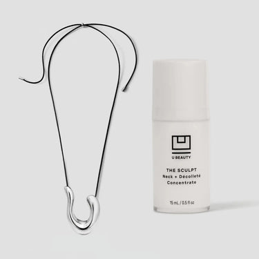 Collier en fil noir avec un pendentif argenté incurvé, présenté à côté d'un flacon de concentré U Beauty Sculpt.