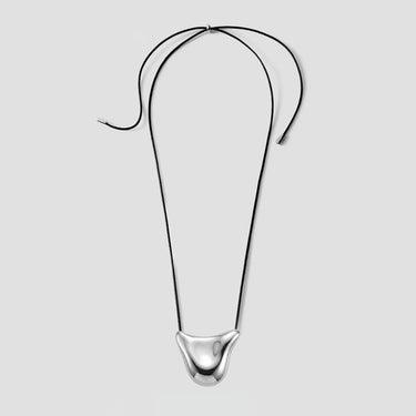 Collier en fil métallique noir courbé, orné d'un pendentif sculptural en argent poli au centre, dans la partie inférieure.