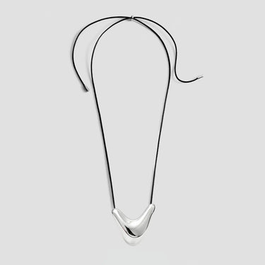 Collier en cordon noir orné d'un pendentif incurvé en argent poli au centre, présenté à plat sur un fond blanc.