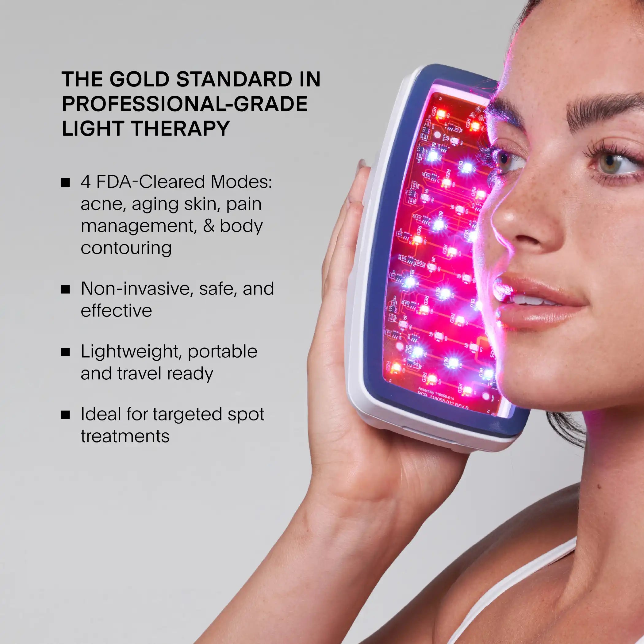 Person holding handheld Celluma LED device with red and pink lights against face.