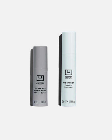 Two cylindrical serum bottles: gray bottle labeled "The Smooth Dynamic Wrinkle Defense Serum" and white bottle labeled "The B