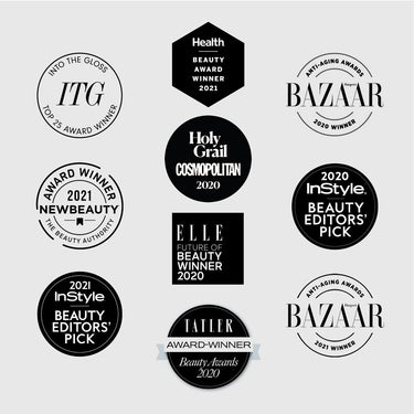 Collection of nine award badges and seals from beauty publications including Health, Bazaar, InStyle, Elle, and Cosmopolitan.